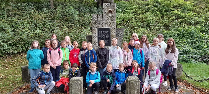 „Zielona szkoła pośród złotych liści spadających z drzew”